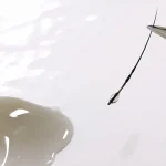 ツイザーで人工毛(エクステ)を持ち松風LED専用グルーを塗布する様子